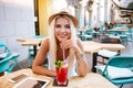 Cheerful woman sitting and drinking cocktail in outdoor cafe Royalty Free Stock Photo
