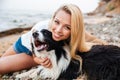 Cheerful woman sitting and hugging her dog on the beach Royalty Free Stock Photo