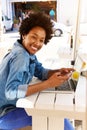 Cheerful woman sitting at outdoor cafe with laptop and cellphone Royalty Free Stock Photo