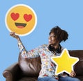 Cheerful woman holding a heart eyes emoticon and star icons Royalty Free Stock Photo
