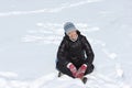 Cheerful woman squating cross-legged on snow Royalty Free Stock Photo