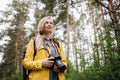 Cheerful woman standing at spring forest with digital camera Royalty Free Stock Photo