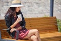 Cheerful woman in the street drinking morning coffee in sunshine light