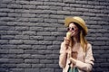 Cheerful woman in sunglasses with ice cream in hands outdoors black brick wall street style Royalty Free Stock Photo