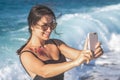 Cheerful woman in a swimsuit takes a selfie by the sea Royalty Free Stock Photo