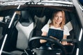 Cheerful woman in T-shirt and overall looking for the problem of her vehicle Royalty Free Stock Photo