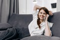 cheerful woman talking on the phone lying on the sofa interior gray plaid Royalty Free Stock Photo