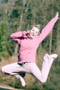 Cheerful woman teenage girl in pink tracksuit jumping outdoor Royalty Free Stock Photo