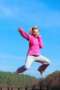 Cheerful woman teenage girl in tracksuit jumping showing outdoor Royalty Free Stock Photo