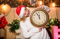 Cheerful woman.. Time to celebrate. xmas mood. Woman wi clock. girl in red santa claus hat. Midnight. winter holidays