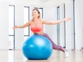 Cheerful woman training with fitball at fitness club. Royalty Free Stock Photo