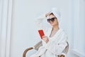 cheerful woman uses a red phone in a chair in a white robe Royalty Free Stock Photo