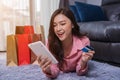 cheerful woman using digital tablet for online shopping with credit card in living room Royalty Free Stock Photo