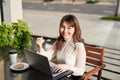 Cheerful woman using laptop and eating cake in a cafe Royalty Free Stock Photo