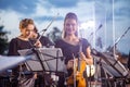 Cheerful woman violin player playing in orchestra outdoors Royalty Free Stock Photo