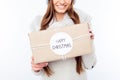 Cheerful woman in warm hat and scarf holding package and congratulate with xmas