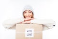 Cheerful woman in warm hat and scarf with package congratulate with xmas