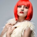 Cheerful woman in white fake fur coat in hot red party wig Royalty Free Stock Photo