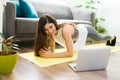 Cheerful woman working out with a video tutorial in the living room Royalty Free Stock Photo