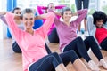 Cheerful women doing sit ups on hardwood floor Royalty Free Stock Photo