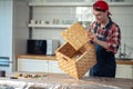 Cheerful woodworker assembling the box in the kitchen