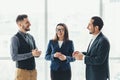 Cheerful work team during break time in office, chatting lively. Royalty Free Stock Photo