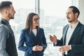 Cheerful work team during break time in office, chatting lively. Royalty Free Stock Photo