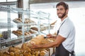 Cheerful worker standing and presenting a bread Royalty Free Stock Photo