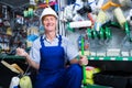 cheerful workman in hardhat buying painting roller Royalty Free Stock Photo