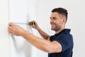 cheerful workman measuring white cabinets of Royalty Free Stock Photo