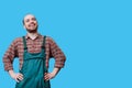 Cheerful workman smiles in studio shot with arms on hips this young professional exudes positivity Royalty Free Stock Photo
