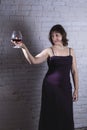 Cheerful 40 years old woman in classic dress with glass of wine Royalty Free Stock Photo