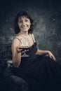 Cheerful 40 years old woman in classic dress with glass of wine Royalty Free Stock Photo