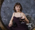 Cheerful 40 years old woman in classic dress with glass of wine Royalty Free Stock Photo