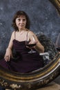 Cheerful 40 years old woman in classic dress with glass of wine Royalty Free Stock Photo