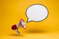 Cheerful yellow background with red megaphone and speech bubble, attention grabbing message Royalty Free Stock Photo