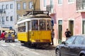 Cheerful yellow tram making it`s way through central Lisbon.