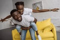 cheerful young african american couple piggybacking and having fun