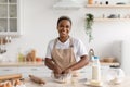 Cheerful young african american female chef blogger in apron making pie dough Royalty Free Stock Photo