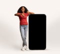 Cheerful Young African American Lady Leaning And Pointing At Big Blank Smartphone Royalty Free Stock Photo