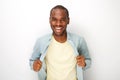 Cheerful young african american man holding shirt open by white background Royalty Free Stock Photo