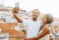 Cheerful young african american man hugging lady in dress, take selfie, photo for social networks Royalty Free Stock Photo