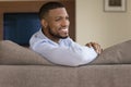 Cheerful young African American man resting on comfortable couch Royalty Free Stock Photo