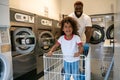 Joyous father playing with his child at a public launderette