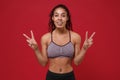 Cheerful young african american sports fitness woman in sportswear posing working out isolated on red wall background Royalty Free Stock Photo