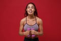 Cheerful young african american sports fitness woman in sportswear working out isolated on red background in studio Royalty Free Stock Photo