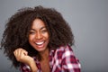 Cheerful young african american woman with curly hair laughing on gray background Royalty Free Stock Photo