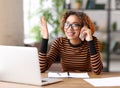 Cheerful young african american woman talking someone on mobile phone while working remotely or studying online from home Royalty Free Stock Photo