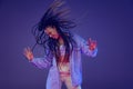 Cheerful young african girl in jeans and shirt dancing, having fun isolated on dark blue background. Concept of beauty Royalty Free Stock Photo