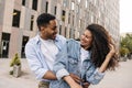 Cheerful young african guy with girl look at each other relaxed walking outdoors. Royalty Free Stock Photo